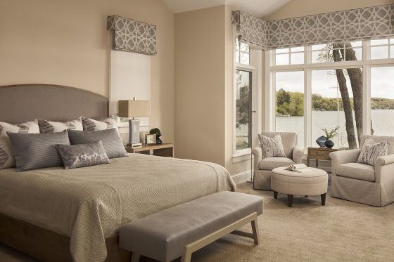 master bedroom, neutral palette, arm chairs, round ottoman, bench, window treatments, pillows, bedding, table lamp, accessories, carpet 