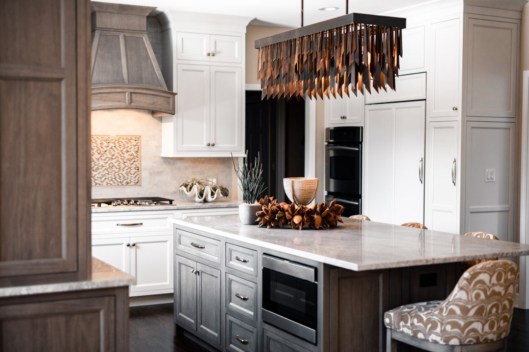 dark bronze chandelier with mutliple metal shards, suburban Chicago kitchen, white and grey cabinets, countertop accessories, 