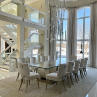 modern dining room, glass-topped table, white dining chairs, rug, chandelier, high ceilings, window treatments, ceiling-to-floor windows