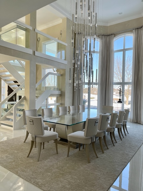 modern dining room, glass-topped table, white dining chairs, rug, chandelier, high ceilings, window treatments, ceiling-to-floor windows 
