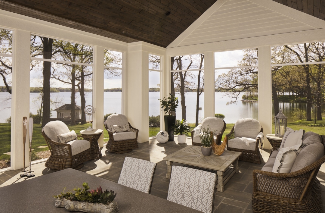 covered porch, lake home, swivel wicker chairs, dining table and chairs, cocktail table, accessories, lake view, tile floor, wicker sofa