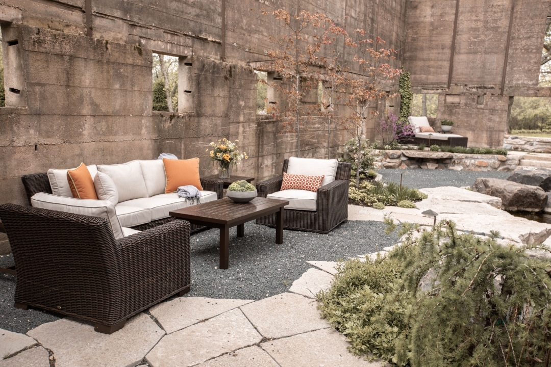 silo, outdoor patio, wicker furniture, white cushions, orange pillows, cocktail table, pavers