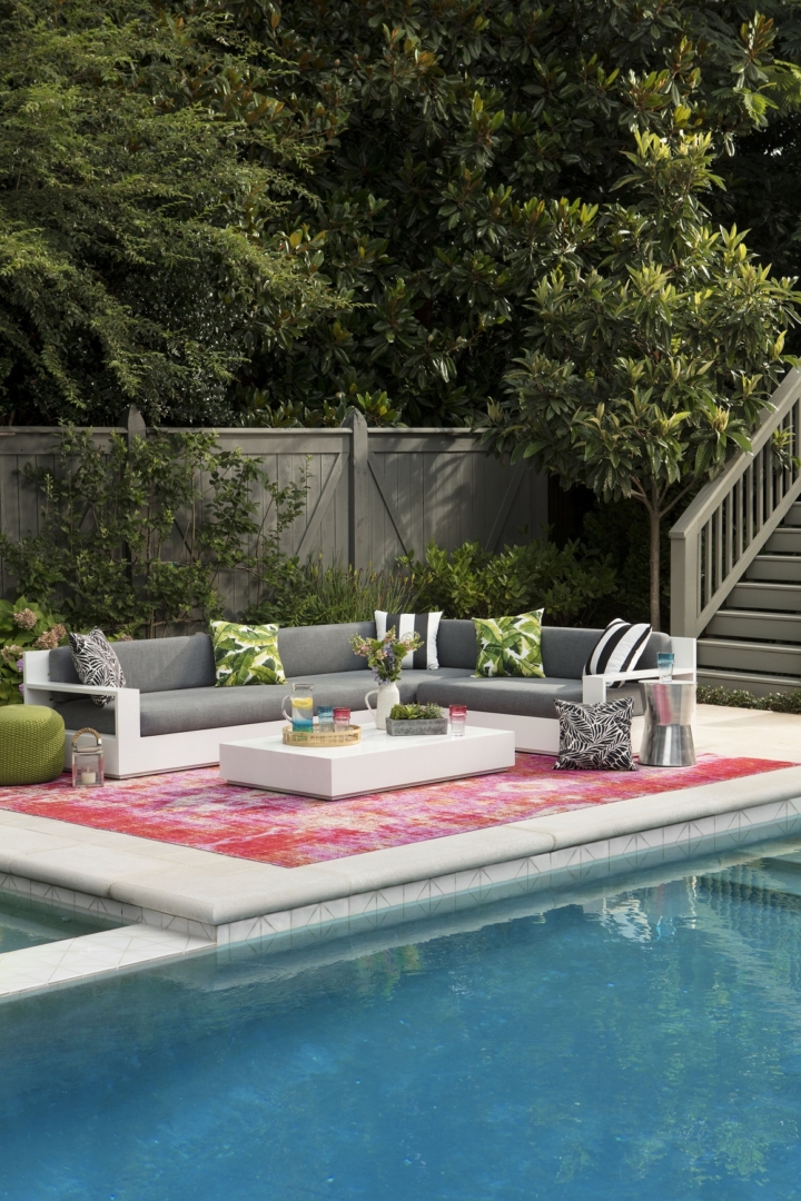 outdoor pool, coral colored outdoor rug, outdoor sectional sofa, outdoor cocktail table, outdoor pillows 