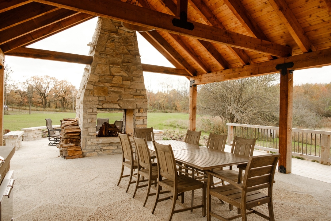 stone patio, stone fireplace, outdoor dining table and chairs