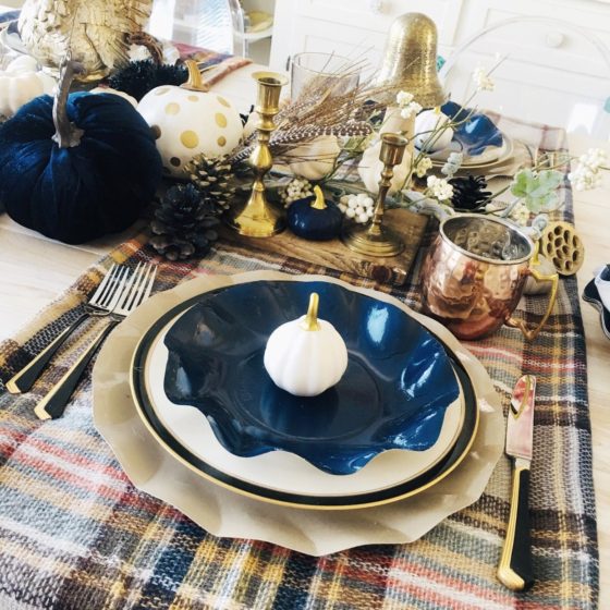 Rich jewel tones give this tablescape a warm autumn aesthetic, with plaid table runners accented with splashes of deep midnight blue and glimmers of gold.